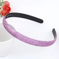Detail of purple glitter headband with anti-slip inner teeth against a white ceramic cup - Purple