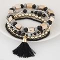 Detail eines Boho-Armband-Sets mit schwarzen Quasten und goldenen Perlen - Schwarz