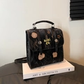 Schwarzer Retro-Rucksack mit Knitteroptik und bunten Stickereien auf weißem Buch - Schwarz