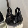 Borsa hobo nera lucida con ciondolo intrecciato su espositore bianco elegante - Con Ciondolo / Nero