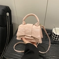 Pink minimalist crossbody handbag with wrinkled leather texture and top handle shown in hand - Pink