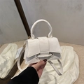 Detail of cream crossbody bag with textured faux leather and unique buckle on top handle - White