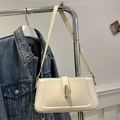Minimalist cream white baguette shoulder bag featuring a sleek golden metal buckle detail - White