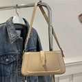 Beige minimalist baguette bag with gold buckle on blue denim background - Khaki