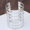 Brazalete ancho de varias capas de plata pulida brillante sobre un soporte de exhibición - Plateado