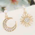 Macro detail of asymmetric moon and sunburst stud earrings with pavé crystal settings - Gold