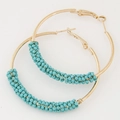 Detail of gold hoop earrings with hand-wrapped turquoise seed beads on white background - Blue