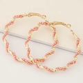 Bohemian gold twisted hoop earrings with pink seed bead accents in a circular design - Pink
