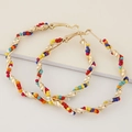 Golden twisted hoop earrings with colorful seed beads and minimalist metallic finish - Colorful