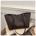 Detail of dark brown tote bag featuring a classic woven pattern on a soft fabric surface - Brown