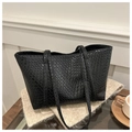 Close-up of black woven leather texture on a large tote bag with slim shoulder straps - Black