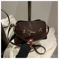 Gros plan détaillé du sac à main marron foncé brillant avec boucle en métal doré - Marron