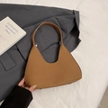 Brown textured leather crescent hobo bag with protective metal feet on a blazer - Brown