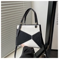 Detalle de bolso de cuero patchwork geométrico con textura tejida y pespuntes claros - Negro