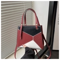 Detalle de mini bolso geométrico con costuras en rojo negro blanco y texturas trenzadas - Rojo
