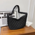 Elegante bolso tote acolchado negro con costuras de diamante en un soporte de madera rústica - Negro