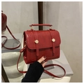 Détail d'un sac à dos rouge en similicuir avec boucles vintage sur socle blanc - Rouge