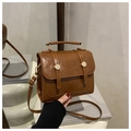 Detail of caramel brown vintage satchel with gold rivet buckles and glossy finish - Brown