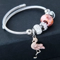 Macro detail of beaded bracelet featuring pink flamingo charm and sparkling rhinestones - Pink