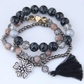 Dettaglio del bracciale boho multistrato con perle marmorizzate, ciondolo e nappa di seta - Nero