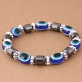 Macro shot of blue Evil Eye beads and dark grey hematite cylinders on an elastic bracelet - Blue (015072662)