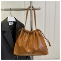 Detail of caramel soft leather bucket bag with drawstring and silver bow decoration - Brown