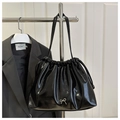 Detail of glossy black pleated shoulder bag featuring a silver metal bow and drawstring - Black