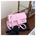 Dettaglio della borsa rosa in pelle PU con logo JINGPIN dorato su un libro decorativo - Rosa