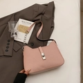 Minimalist light pink shoulder bag with textured leather and chain strap on a blazer - Pink