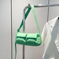 Mint green quilted crossbody bag featuring dual front pockets and adjustable strap - Green