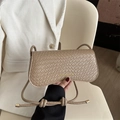 Beige shoulder bag with woven texture and gold fashion logo shown in hand - Khaki