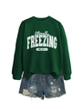 Flat lay of green 'literally freezing' sweatshirt paired with distressed denim shorts - S / Tops / Dark Green