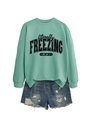 Detail of mint green sweatshirt with 'literally freezing' print and ripped denim shorts - S / Tops / Light Green (Black Print)