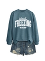 Flat lay of blue sweatshirt with 'literally FREEZING ME' text and ripped denim shorts - S / Tops / Blue (White Print)