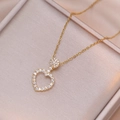Macro shot of gold heart pendant necklace with clear zircon pavé in a champagne gift box - Necklace (X2672) / Gold
