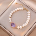 Elegante bracciale di perle bianche con zircone viola centrale e chiusura dorata - Bracciale di Perle d'Acqua Dolce Zircone Viola (TS0394)