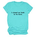 Détail à plat du t-shirt turquoise avec l'imprimé texte 'I closed my book to be here' en noir - Bleu Eau Profonde (Police Noire)