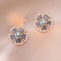 Elegant gold flower earrings with blue cubic zirconia on a pink satin background - Flower Style (E0855)