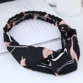 Detail eines Stirnbandes mit Knotendesign und rosa Flamingomuster auf schwarzem Stoff - Schwarz