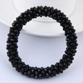 Detail of faceted black crystal beads on a stretch bracelet with polished surfaces - Black
