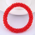 Detail of red multilayer beaded bracelet with faceted cut crystals on white plate - Red