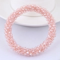 Detailed view of hand-woven pale pink faceted crystal bead bracelet on a ceramic dish - Pink