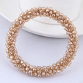 Detailed view of faceted champagne crystal bead bracelet on a white minimalist tabletop - Champagne