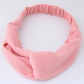 Pink knitted wide headband with twist knot design and elastic band on white background - Pink