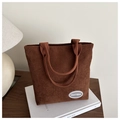 Detail of dark brown corduroy tote bag featuring a vintage logo patch and soft texture - Brown