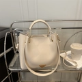 Schicke beige Eimer-Handtasche aus Leder mit Rundgriff und goldenen Metalldetails - Weiß