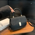 Black luxury crossbody bag with glitter flap and golden hardware in stylish setting - Black
