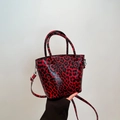 Trendige Eimer-Tasche mit rot-schwarzem Leopardenmuster und glänzendem Finish - Rot (Rot-Schwarz Leopard)