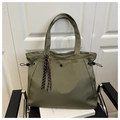 Detailed view of an olive green nylon tote bag featuring magnetic buckle and woven tassels - With Charm / Green