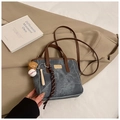 Detail der grauen Denim-Beuteltasche mit braunen Lederriemen und Baseball-Anhänger - Mit Anhänger / Blau